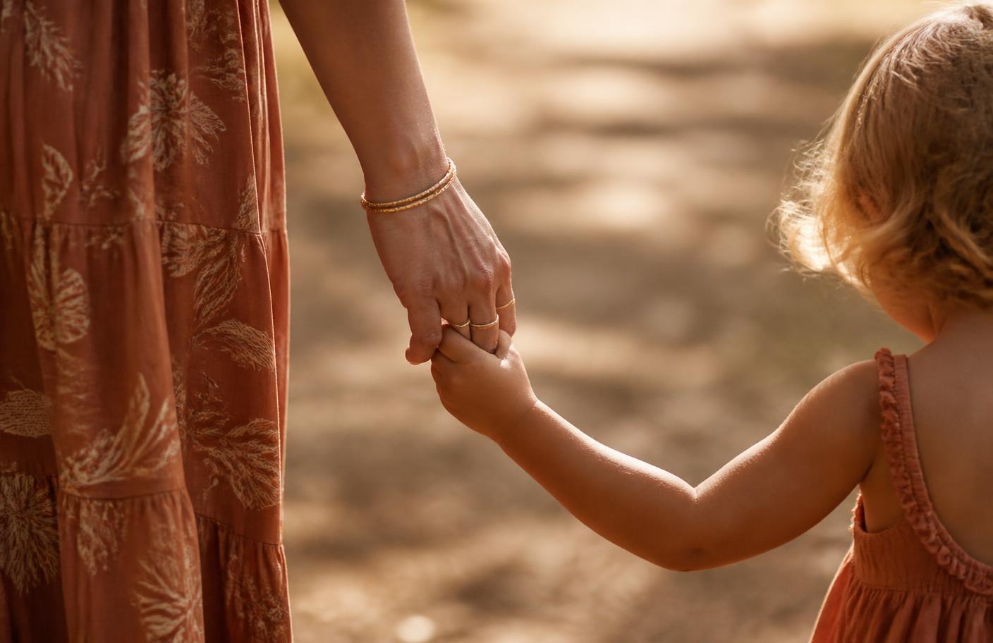 Mãe segurando a mãozinha do filho